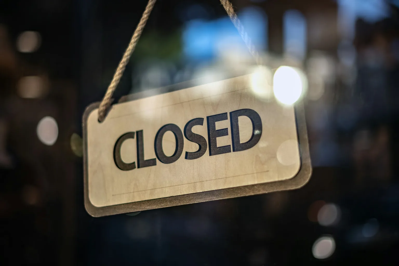 玻璃門上掛著的 CLOSED 告示牌